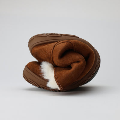 Vaistoa Huurre – paljasjalkabootsit talveen, väri karamellinruskea. Kuvassa kengän ohut ja joustava pohja rullattuna – kuva havainnollistaa pohjan taipuisuutta ja luonnollista askellusta tukevaa rakennetta.