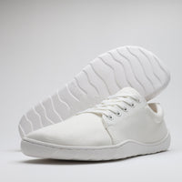 Vaistoa Rento 2 paljasjalkakengät, matalavartiset kangastennarit – valkoinen kenkä ja ulkopohja esillä viistosti valkoista taustaa vasten